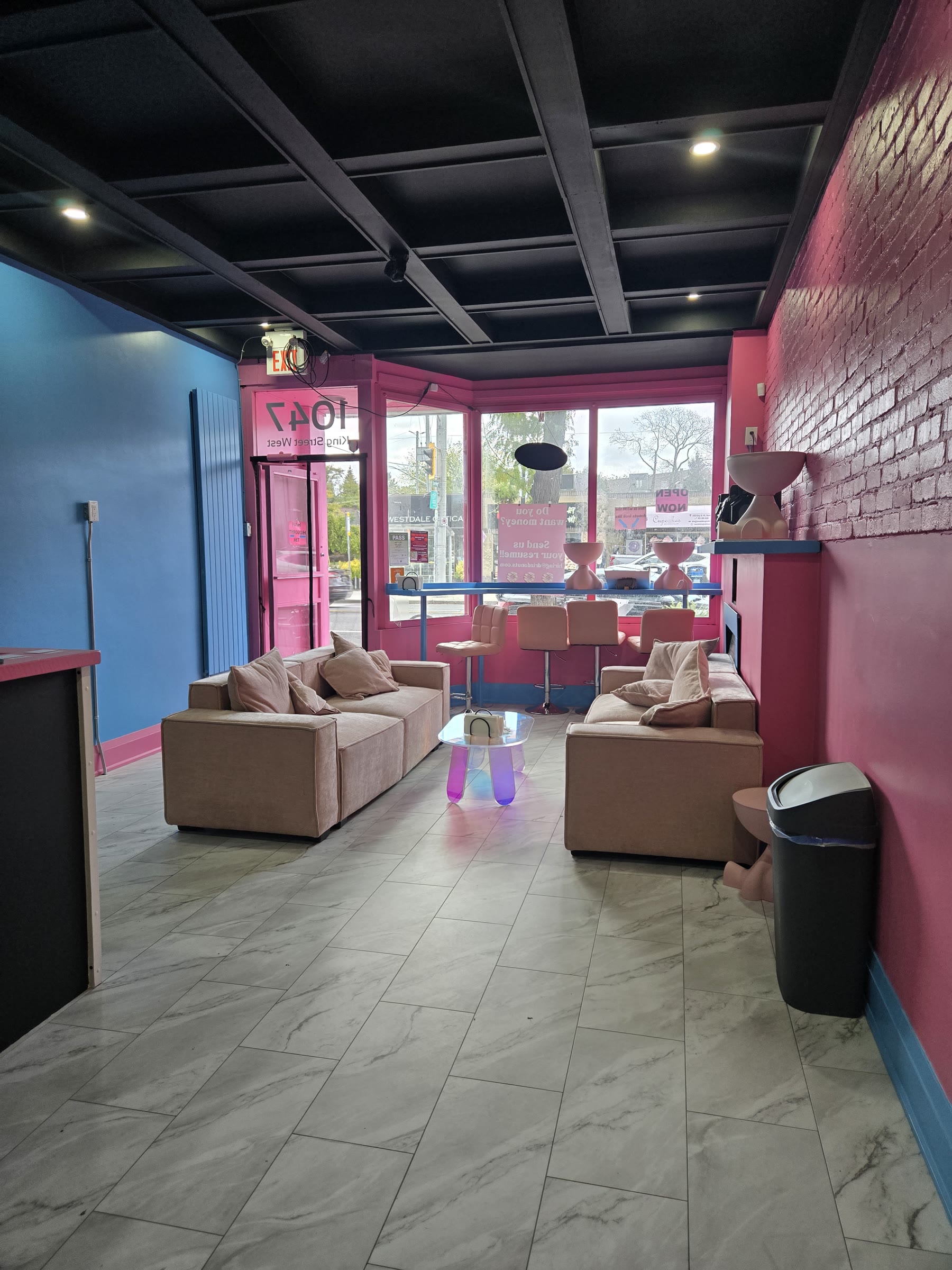 Commercial storefront interior with lounge seating, feature lighting and bold wall colours