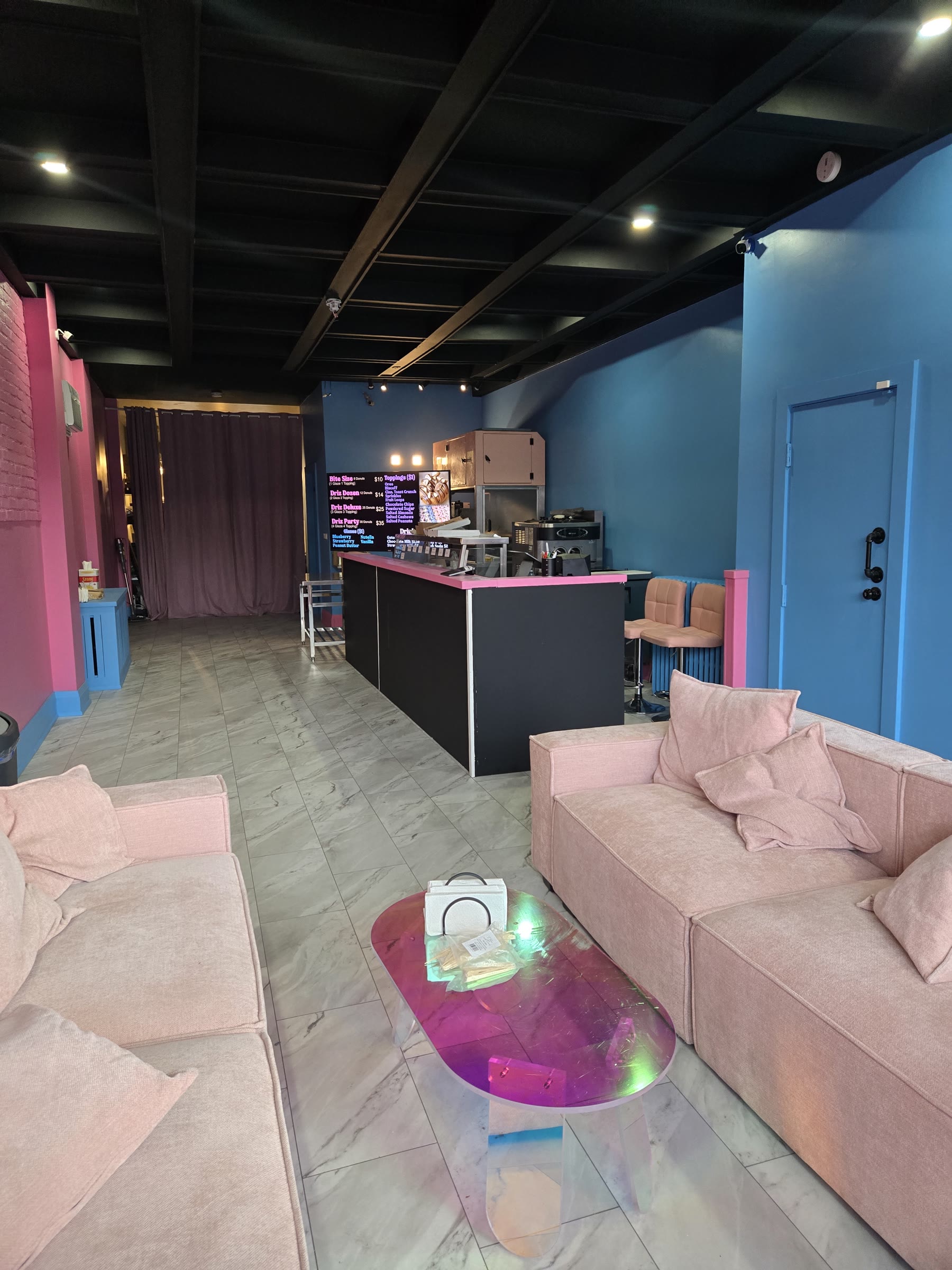 Commercial seating zone and service counter under a dark open ceiling